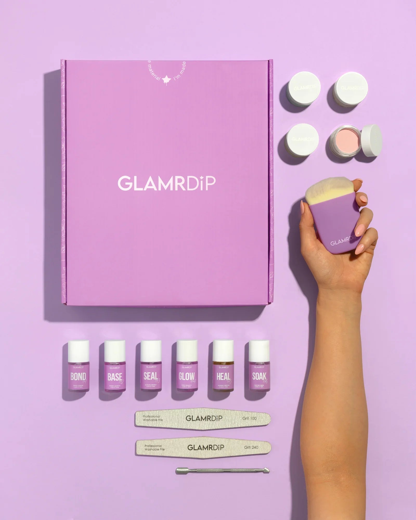 GLAMRDiP Salon Kit flatlay med udstyr til hjemmemanicure — lilla gaveæske, 6 væskeflasker, krukker med dip powder, neglefile, neglebørste og neglebåndsskubber